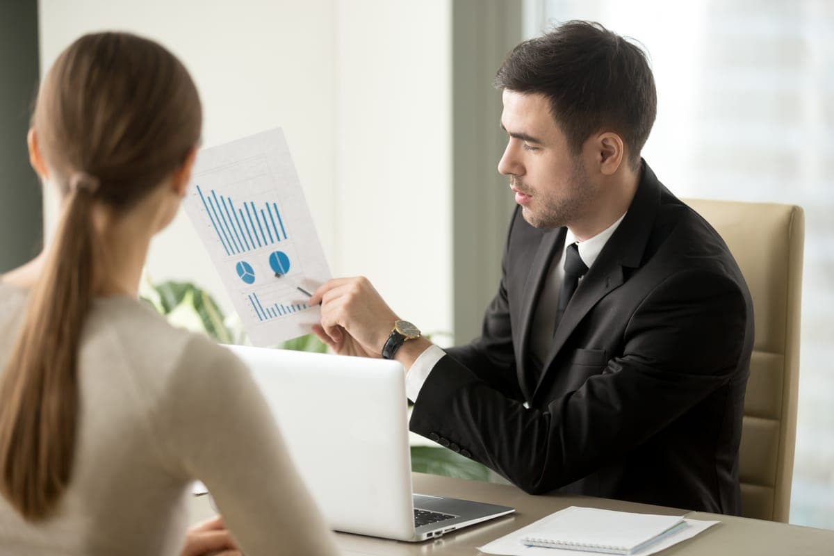 Two managers going through a demand chart across a desk